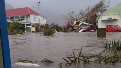 TOPSHOT - This handout picture released on September 6, 2017, on the twitter account of RCI.fm shows a flooded street on the French overseas island of Saint-Martin, after high winds from Hurricane Irma hit the island. Monster Hurricane Irma slammed into Caribbean islands today after making landfall in Barbuda, packing ferocious winds and causing major flooding in low-lying areas. As the rare Category Five storm barreled its way across the Caribbean, it brought gusting winds of up to 185 miles per hour (294 kilometers per hour), weather experts said. / AFP PHOTO / TWITTER AND rci.fm / Rinsy XIENG / RESTRICTED TO EDITORIAL USE - MANDATORY CREDIT 'AFP PHOTO / RCI.fm/ Rinsy XIENG' - NO MARKETING NO ADVERTISING CAMPAIGNS - DISTRIBUTED AS A SERVICE TO CLIENTS --