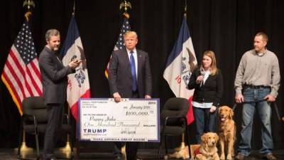 Trump presenta un cheque de la Fundación Trump al Puppy Jake el 30 de enero de 2016 en Davenport, Iowa. AFP/Archivo