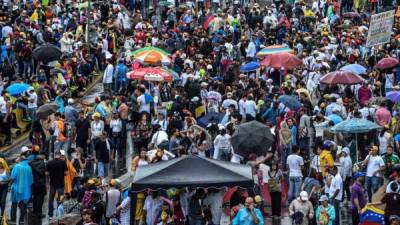 Venezuelan opposition activists take part in a rally against the government of President Nicolas Maduro, in Caracas, on May 15, 2017.Venezuelans launched a seventh week of anti-government demonstrations by blocking roads on Monday, vowing not to budge all day in protest at a deadly political and economic crisis. / AFP PHOTO / Juan BARRETO