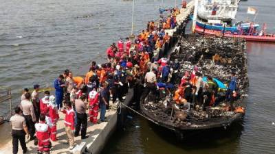 Rescatistas examinan los restos del ferry incendiado.