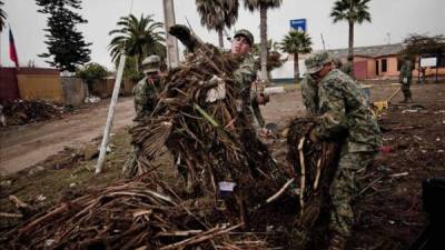 Un grupo de militares chilenos despejan las algas de las calles principales del puerto de la localidad de Coquimbo, a unos 460 kilómetros al norte de Santiago, tras el tsunami que afectó a la zona la noche del 16 de Septiembre. EFE/Archivo