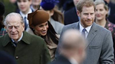 (FILES) In this file photo taken on December 25, 2017 (L-R) Britain's Prince Philip, Duke of Edinburgh, US actress and fiancee of Britain's Prince Harry Meghan Markle and Britain's Prince Harry (R) arrive to attend the Royal Family's traditional Christmas Day church service at St Mary Magdalene Church in Sandringham, Norfolk, eastern England. - Prince Harry and wife Meghan Markle's foundation Archewell paid tribute to Britain's Prince Philip following his death on April 9, 2021 as speculation builds about their plans to attend the funeral. (Photo by Adrian DENNIS / AFP)
