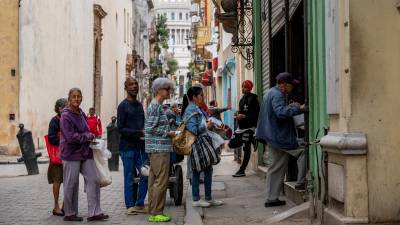 Un grupo de personas hace fila en una panadería en La Habana.
