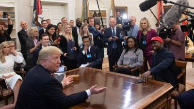 El presidente de los Estados Unidos, Donald Trump, se reunió con el rapero Kanye West (gorra roja d) en la Oficina Oval de la Casa Blanca en Washington, DC, el 11 de octubre de 2018. Foto AFP/ SAUL LOEB