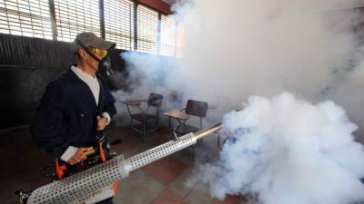 Personal del Ministerio de Salud fumigan un salón de clases contra el mosquito Aedes aegypti , vector del dengue, el chikungunya y Zika virus en Tegucigalpa. AFP