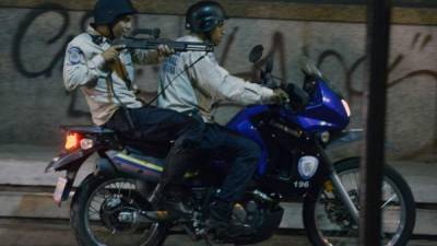 Un guardia civil montado en una moto apunta su escopeta durante enfrentamientos con activistas de la oposición en Caracas, el 4 de abril de 2014.