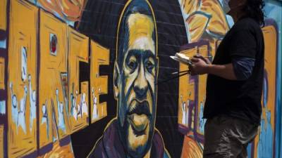 Un artista pinta un mural de George Floyd. Foto: AFP