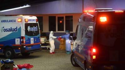 Personal medico se desinfecta después de ingresar a un paciente con coronavirus en un hospital de San Salvador.