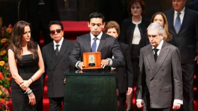 El hijo mayor de Juan Gabriel, Iván Aguilera (c), acompañado de su esposa, Simona Hakman (i), y el secretario mexicano de Cultura, Rafael Tovar y de Teresa (d), sostiene las cenizas de su padre hoy, lunes 5 de septiembre de 2016, durante homenaje de dos días en el Palacio de Bellas Artes de Ciudad de México (México). EFE/José Méndez