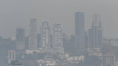 Las personas están padeciendo enfermedades respiratorias por densa capa de humo. (Photo by Orlando SIERRA / AFP)