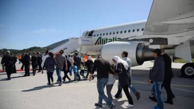 Un grupo de refugiados sirios sube al avión con el papa Francisco en el aeropuerto de Mitilene, en la isla de Lesbos, Grecia. Foto de EFE.
