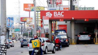 Fotografía de un grupo de gente realizando fila para entrar a un BAC Credomatic, este lunes, en Tegucigalpa. EFE