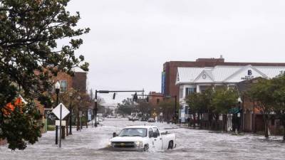 A city worker drives through the flooded street during Hurricane Sally in downtown Pensacola, Florida on September 16, 2020. - Hurricane Sally barrelled into the US Gulf Coast early Wednesday, with forecasts of drenching rains that could provoke 'historic' and potentially deadly flash floods.The National Hurricane Center (NHC) said the Category 2 storm hit Gulf Shores, Alabama at about 4:45 am (0945 GMT), bringing maximum sustained winds of about 105 miles (165 kilometers) per hour.'Historic life-threatening flooding likely along portions of the northern Gulf coast,' the Miami-based center had warned late Tuesday, adding the hurricane could dump up to 20 inches (50 centimeters) of rain in some areas. (Photo by CHANDAN KHANNA / AFP)