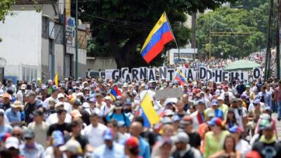 Opposition activists march during a protest against President Nicolas Maduro's government, in Caracas on May 31, 2017.Venezuelan authorities on Wednesday began signing up candidates for a planned constitutional reform body, a move that has inflamed deadly unrest stemming from anti-government protests. Opponents of socialist President Nicolas Maduro say he aims to keep himself in power by stacking the planned 'constituent assembly' with his allies. / AFP PHOTO / FEDERICO PARRA