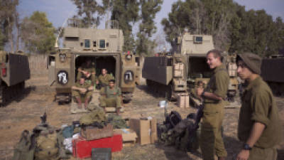 Israeli soldiers sit near their belongings before leaving a deployment area near the Israel-Gaza Strip border on November 22, 2012, a day after a cease fire was declared between the Jewish state and Hamas. Defence Minister Ehud Barak warned that Israel may resume its attacks on Gaza at any time if a truce that ended a week of bloodshed fails to hold. AFP PHOTO/MENAHEM KAHANA