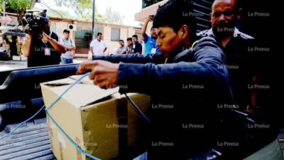 El cuerpo del bebé es cargado en una caja por su padre.