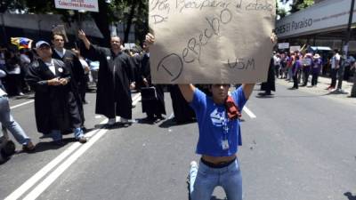 A students takes part in a protest of lawyers in Caracas on May 21, 2014. At least 18 public and private universities in Venezuela began on Thursday a 24-hour strike to demand the release of more than a hundred students arrested during the three months of anti-government protests, which left 42 dead. AFP PHOTO/JUAN BARRETO