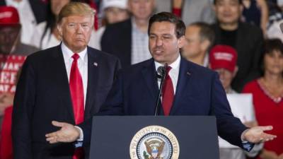 PENSACOLA, FL - NOVEMBER 03: Florida Republican gubernatorial candidate Ron DeSantis speaks with U.S. President Donald Trump at a campaign rally at the Pensacola International Airport on November 3, 2018 in Pensacola, Florida. President Trump is campaigning in support of Republican candidates in the upcoming midterm elections. Mark Wallheiser/Getty Images/AFP