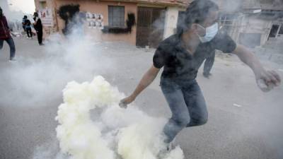 Un manifestante trata de evitar unas cápsulas de gas lacrimógeno durante unos enfrentamientos en la ciudad de Duraz, al norte de Manama, Baréin, el 29 de enero. EFE/Archivo
