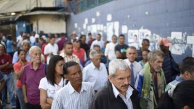 Venezuelans queue outside a polling station as they wait to cast their vote during the presidential elections in Caracas on May 20, 2018Venezuelans, reeling under a devastating economic crisis, began voting Sunday in an election boycotted by the opposition and condemned by much of the international community but expected to hand deeply unpopular President Nicolas Maduro a new mandate / AFP PHOTO / Federico Parra