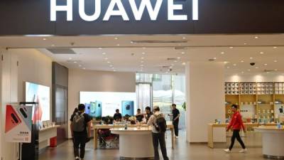 La gente busca artículos en una tienda de Huawei en un centro comercial en Shanghai el 22 de mayo de 2019. (Foto por Hector RETAMAL / AFP)