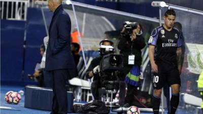 James Rodríguez pasa por detrás de Zinedine Zidane tras ser sustituido en el partido Leganés-Real Madrid. Foto EFE