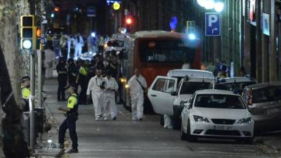 Forensic policemen arrive in the cordoned off area after a van ploughed into the crowd, killing 13 persons and injuring over 80 on the Rambla in Barcelona on August 17, 2017.A driver deliberately rammed a van into a crowd on Barcelona's most popular street on August 17, 2017 killing at least 13 people before fleeing to a nearby bar, police said. Officers in Spain's second-largest city said the ramming on Las Ramblas was a 'terrorist attack'. / AFP PHOTO / Josep LAGO