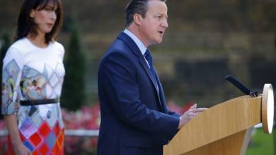 El primer ministro británico, David Cameron, flanqueado por su esposa, Samantha, anuncia su dimisión al cargo.