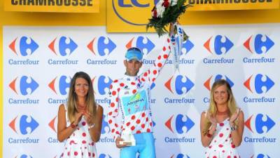 El líder de la clasificación general, el italiano Vicenzo Nibali (c), del equipo Astana, se viste con el maillot de puntos rojos de rey de la montaña al término de la decimotercera etapa del Tour de Francia, de 197,5 kilómetros entre las localidades de Saint-Etienne y Chamrousse, Francia, hoy, viernes 18 de julio de 2014. EFE/Nicolas Bouvy
