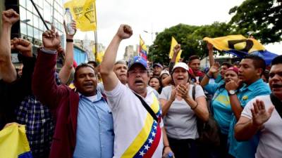 Partidarios de la oposición venezolana se concentran frente a la de la Asamblea Nacional en apoyo de sus diputados electos el día de su instalación. AFP