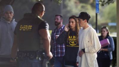 Familiares y amigos de las víctimas dialogan con los policías tras el tiroteo de esta madrugada.