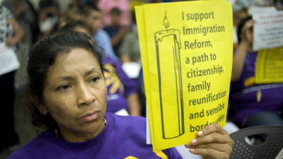 La hispana Marisa Magaña sostiene un letrero durante una reunión del Ayuntamiento con el congresista Duncan Hunter Jr.
