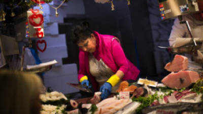 A fishmonger prepares fish for a client in a market in Barcelona, Spain, Thursday Jan. 17, 2013. Spain has sold euro4.5 billion ($5.97 billion) in a medium- and long-term bond sale that saw interest rates dropping as market fears ease over whether the country will need outside help to manage its finances. (AP Photo/Emilio Morenatti)