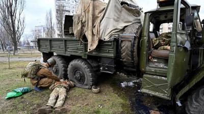 Un médico ucraniano revisa los cuerpos de dos militares rusos acribillados en las afueras de Kiev.