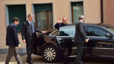 El exprimer ministro italiano Silvio Berlusconi saluda a los periodistas a su salida del centro de la Fundación Sagrada Familia.