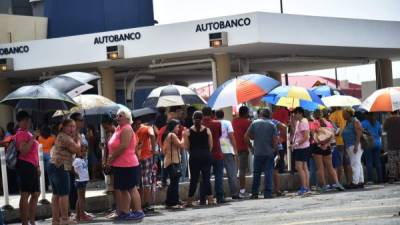 Puertorriqueños hacen largas filas para poder usar los cajeros automáticos y retirar algo de dinero para comprar víveres.