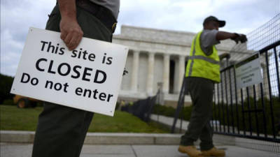 Dos empleados del servicio de parques de Estados Unidos colocan vallas y carteles que impiden el paso al Memorial Lincoln, en Washington (Estados Unidos).