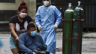 Un paciente con síntomas del coronavirus COVID-19 busca asistencia en las carpas del Hospital Escuela. AFP