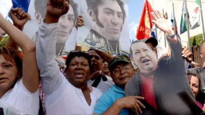 Simpatizantes chavistas portanto las imágenes del Libertador, Simón Bolívar y Hugo Chávez, en las calles de Caracas.