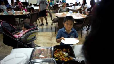 Voluntarios sirven comida en el centro de asistencia para inmigrantes en Escondido, California (Estados Unidos), durante la inauguración de un centro de servicio para inmigrantes, iniciativa de la Primera Iglesia Metodista de Escondido que pretende proveer de diversas asistencias para inmigrantes, enfocados en los centroamericanos que buscan asilo en Estados Unidos. EFE