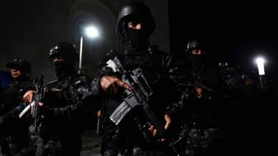 Police officers stand at attention in the historic centre of San Salvador on June 20, 2019, during the launch of a new security plan pushed by Salvadoran President Nayib Bukele to reduce violence in areas dominated by gangs. - Bukele, who took office earlier this month, has said a priority of his five-year term is cracking down on gangs that recruit young people into their ranks, while profiting off drug trafficking and extortion. (Photo by MARVIN RECINOS / AFP)