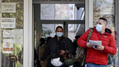 Dos personas salen de un centro de salud protegidos con una mascarilla en Valencia.