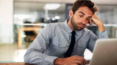 Shot of a young businessman cheering while using a laptop at his desk in an office