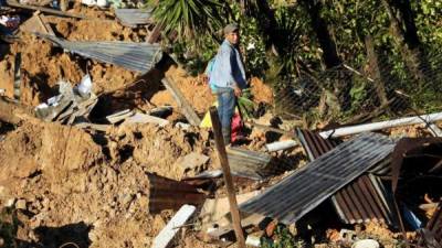 Un habitante de la aldea La Reina en Honduras, camina entre los escombros en el lugar donde quedaron soterradas casas a cusa de las tormentas Eta e Iota en noviembre. Foto EFE