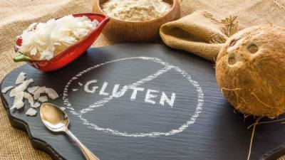 Photo of Coconut, Coconut chips and Coconut flour against a background of burlap with a no gluten chalkboard sign in the front.