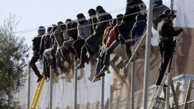 Varios subsaharianos en el vallado entre Melilla y Marruecos. EFE/Archivo