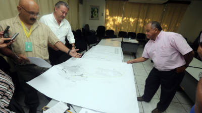 El director del INA, Ramón Lara (centro), rodeado de sus asesores, explicando detalles de los planos del extenso terreno.