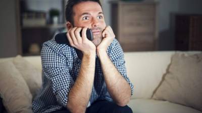 Smiling man watching interesting movie