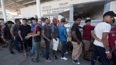 Migrantes hacen fila para registrarse y andar legalmente en México. AFP