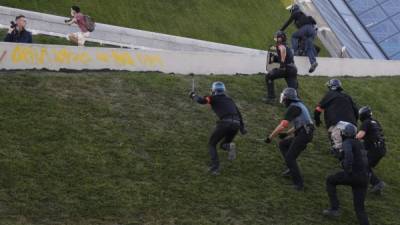French police chase protesters at the Parc de Bercy during a climate change protest in the French capital Paris on September 21, 2019. - Over a hundred demonstrators were arrested at yellow vest protests in Paris, as about 7,500 police were deployed to deal with the movement's radical anarchist 'black blocs' strand. After first marching with the yellow vests, around 1,000 radical demonstrators joined a separate march against climate change where they provoked clashes with police, authorities said. (Photo by Zakaria ABDELKAFI / AFP)